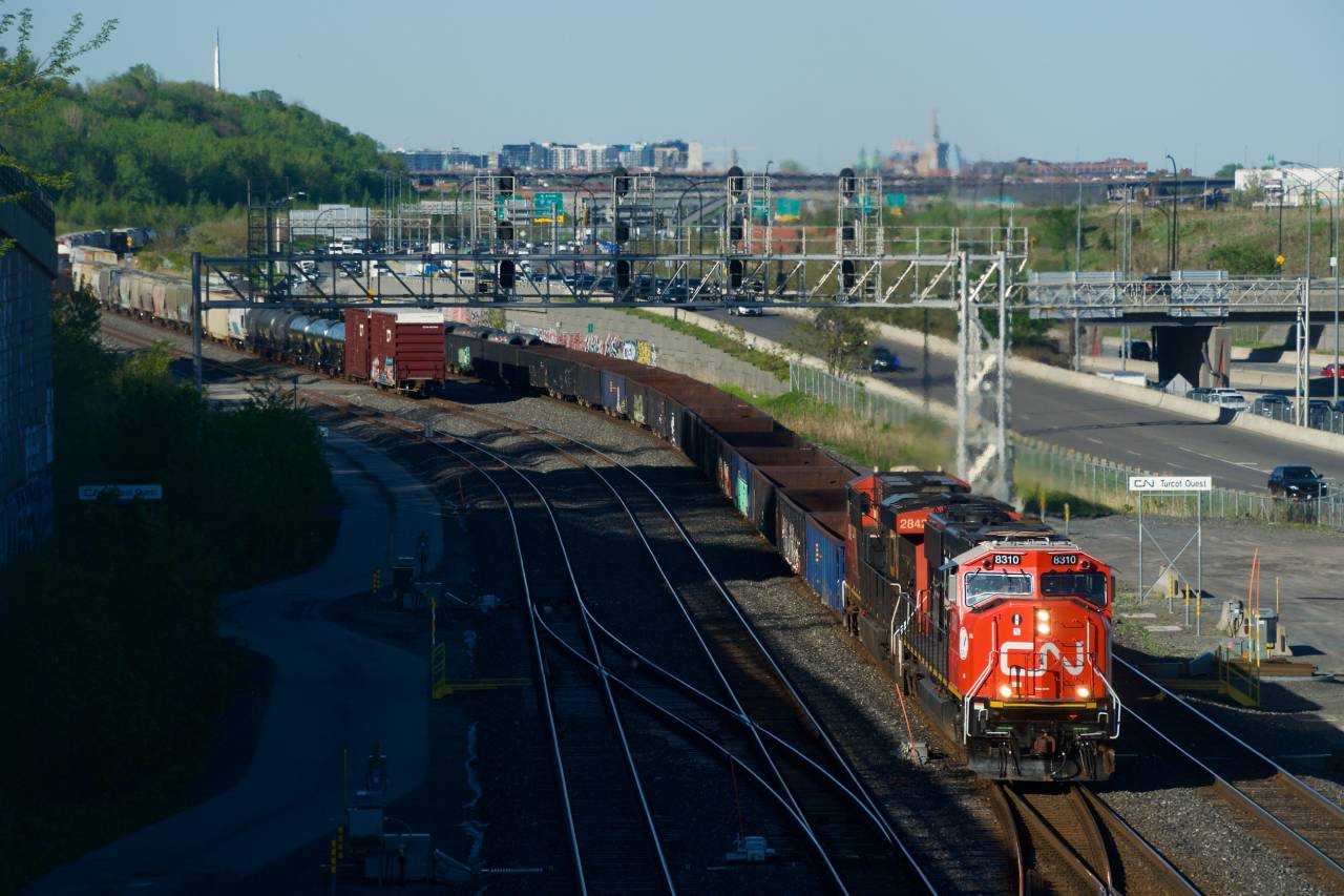 Fresh CN 8310 leads CN 321 past Turcot Ouest, with CN 527's tail end visible at left.