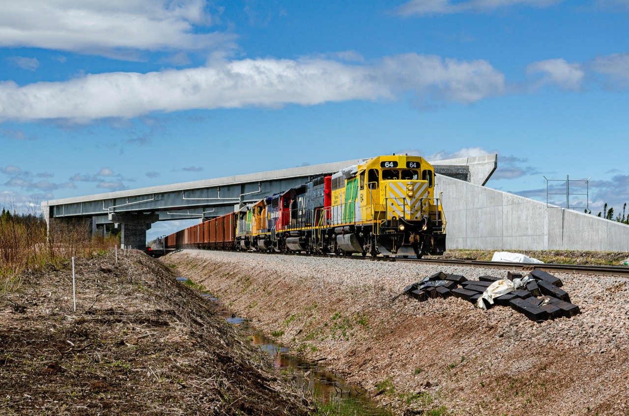 Roberval & Saguenay GP38-2 64, a former CN GP40 rebuilt by AMF in the 1990s leads the mainline train running between Arvida and Port-Alfred. Over the train stands a ''ghost'' freeway viaduct, built for the upcoming extension of the Autoroute 70 between the Bagotville base and the R-170 - R-381 junction.
