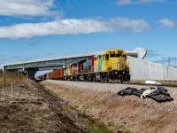 Roberval & Saguenay GP38-2 64, a former CN GP40 rebuilt by AMF in the 1990s leads the mainline train running between Arvida and Port-Alfred. Over the train stands a ''ghost'' freeway viaduct, built for the upcoming extension of the Autoroute 70 between the Bagotville base and the R-170 - R-381 junction. 