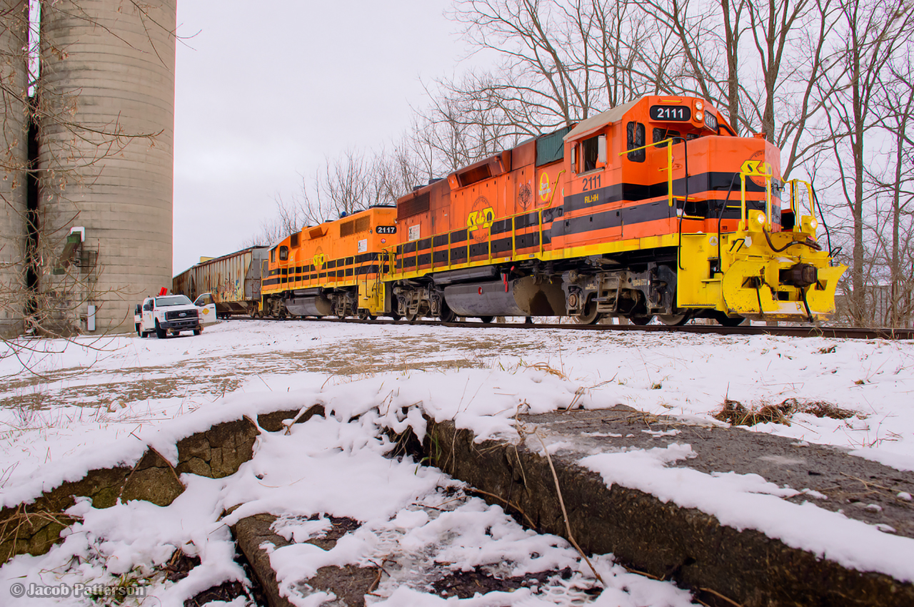 Easing back into the siding at Mitchell, 581 makes a lift and setoff under the watchful eye of a track foreman.  A brief chat, an exchange of coffees, and 581 will be off to Goderich in a few minutes.  

Nestled beneath the nearby trees, a concrete staircase sits abandoned.  Once used by CNR passengers to access the station platform, a revenue passenger has not been seen since the last RDC run in October 1970, with the station gone soon after.