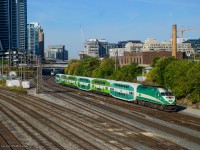 GO 629 shoves Barrie Line train 6911 west by Bathurst Street, while train 3012 from Bramalea, led by GO 660, approaches in the distance.