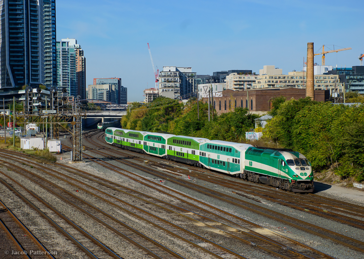 GO 629 shoves Barrie Line train 6911 west by Bathurst Street, while train 3012 from Bramalea, led by GO 660, approaches in the distance.