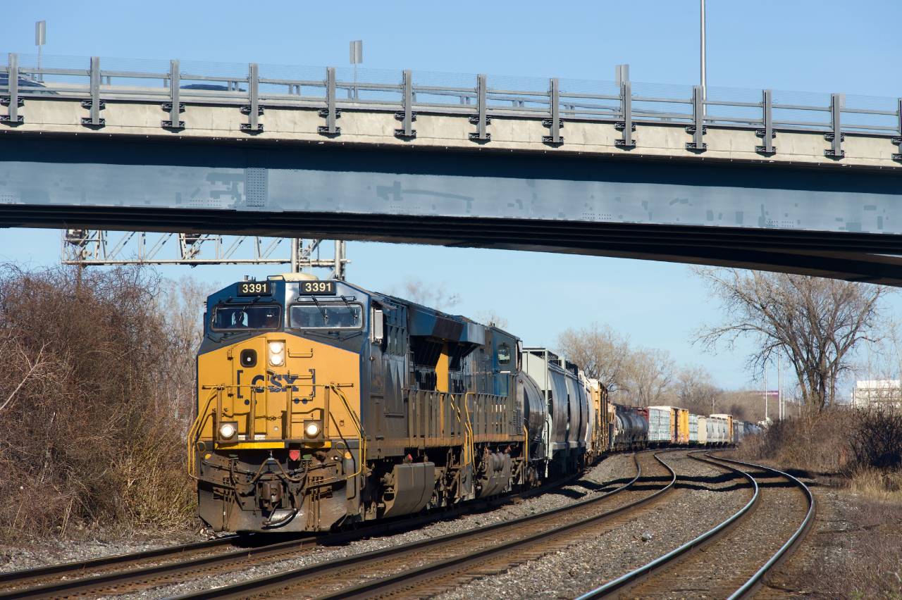 Running out of Montreal overnight during the past year or two, CN 327 (destined for interchange with CSXT closer to the international border and usually running with CSXT power) has gone back to running in the afternoon since a few weeks ago.

Here it is through the s-curve at Dorval with ET44AH CSXT 3391 leading.
