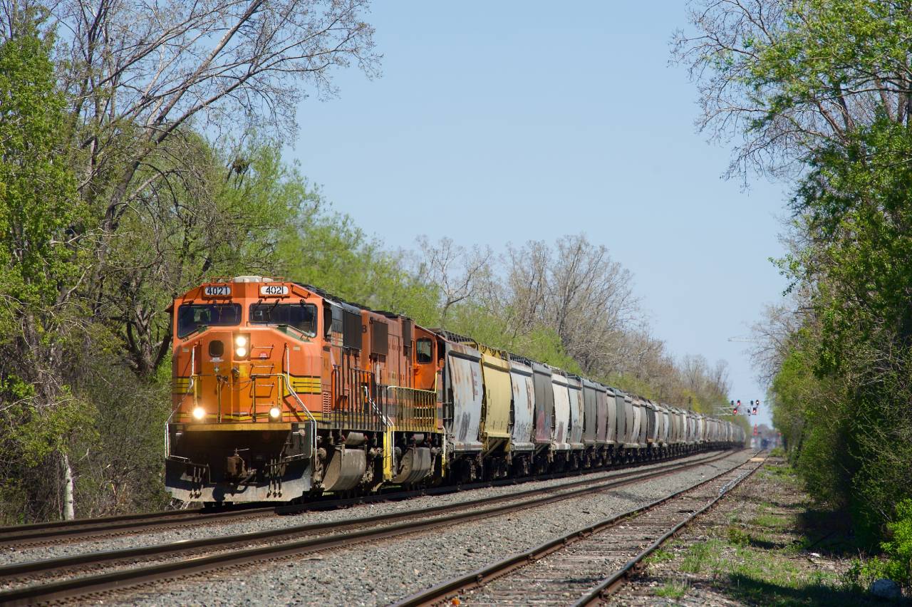An empty Quebec Gatineau grain train is about to enter CPKC's St-Luc Yard with SD70MACs QGRY 4021 & QGRY 4018.