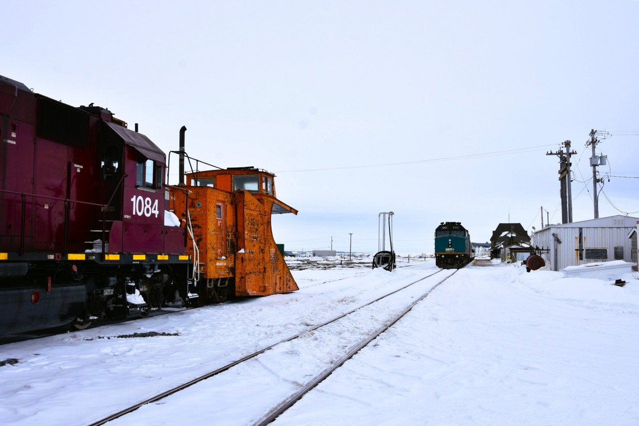 Meeting at the Port  
It's a cool and overcast April 30, 2026 morning in Churchill, MB. 
VIA 693 had backed into the station track at 10:00 and an hour and a half later the HBRY way freight with HBRY 55376 (ex-CN 55376) single track snowplow pulled up alongside. 
The VIA consist will sit idling until 19:30 this same evening while its crew gets their mandatory rest before making the return trip to Winnipeg. 
The HBRY way freight will get a fresh crew right away and start switching todays consist onto various ramp tracks in the yard across from the station. 
It was quite the sight to watch the way freight make all its switch moves with the plow still attached to the locomotives. 
When the switch list was completed the four units and plow headed south out of town to the wye and turned the plow. On return to Churchill, they dropped the plow behind the consist of VIA 692 while they made up their return train.
