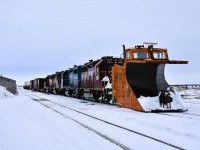 <b> Surprise, Surprise </b> <br>
After arriving in Churchill and having a hearty breakfast at The Seaport Hotel I started my day of photography back at the station platform capturing the consist of VIA 693 and several pieces of equipment in the yard while awaiting the arrival of the HBR way freight. <br>
A headlight finally came into view at the south end of the yard, but it was not the standard triangle of headlight and ditch lights I was expecting. <br>
As the movement got closer, and much to my surprise, I could see the lead equipment on the way freight was HBRY 55376 (ex-CN 55376) mainline snowplow. <br>
The deceiving headlight turned out to be a standard locomotive headlight with only one functioning bulb, and an L.E.D. light bar. <br>
While the overcast skies were not the best light conditions, I think the subject matter more than made up for it. <br> 
The two-man crew of the way freight was very cooperative in my picture taking efforts that morning. <br>
What a great way to start the day in Churchill!