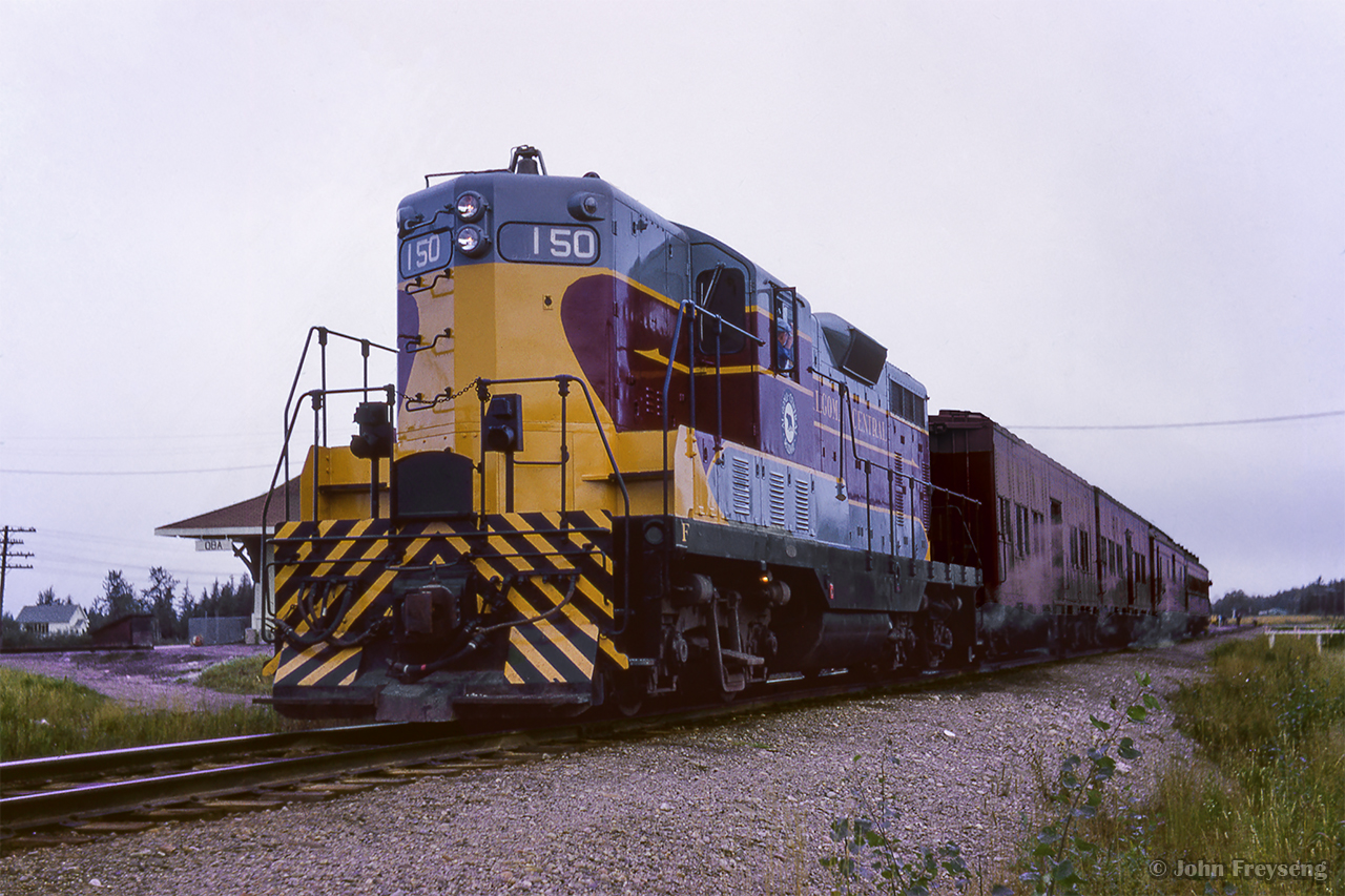Algoma Central Railway train 2, running southbound from Hearst to Sault St. Marie, pauses at CN's Oba station.

Scan and editing by Jacob Patterson.
