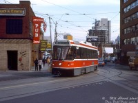 TTC CLRV streetcar 4025 heads westbound on Dundas Street East just past Bond Street, passing the Imperial Pub right where Dundas takes a jog to the north before crossing Victoria Street (also note the track continuing straight, ending at Victoria). On the right is the Bond Place Hotel.<br><br>Opened in 1944, the Imperial Pub was an institute on the doorstep of Yonge Street and Dundas Square that would serve patrons in Toronto for decades, including many Ryerson University (TMU) students that often came to drink, study or hang out upstairs in the library/lounge area. It was finally closed in November 2025 after 81 years, as the site was sold to TMU and will be redeveloped into a student residence building (leaving said students with one less local watering hole to frequent). So goes the Imperial Pub the way of many iconic Toronto venues, including Honest Eds and Sam the Record Man (the latter site also purchased by Ryerson and redeveloped). The Bond Place Hotel was purchased by the City of Toronto in recent years, and is now a shelter building.<br><br><i>William (Bill) Hood photo, Dan Dell'Unto collection slide.</i>
