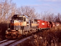 Streetsville has long played a part in my Railfaning life. It has always been my closest location when it comes to photographing CP. Often after college I would take the long route home trough Streetsville just in case anything was around. I soon discovered the local that served local industries here. Originally a single MLW based at Guelph Junction, later it was relocated to West Toronto where it is still located today. Back in the early 2000’s the local was still running daily, Monday to Friday. The ADM Mill was still a big customer for CP in those days, served almost daily and often twice on Wednesday’s, even occasionally served on Saturday’s. Here is one of those rare Saturday runs, dodging winter shadows as it heads back to the mainline. While the spur to the mill wasn’t long it was somewhat scenic travelling trough a tunnel of trees, clinging to the hillside above the Credit River on part of a route proposed so long ago by “booth” when he proposed the Credit Valley Railway follow the River to a connection with the Great Western Railway (now CN) at Port Credit. Although the route was rejected this short spur gives you an idea of what could have been. Unfortunately the more recent years have not been good for ADM’s mill. A change in shipping found the mill totally end rail service and even trucks to the mill don’t seem as frequent. Today the spur has been severed from the mainline and is now badly overgrown. Only time will tell if a revival will ever come. 