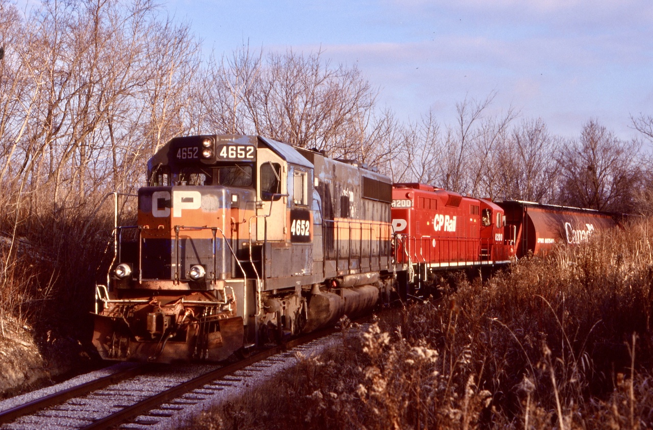 Streetsville has long played a part in my Railfaning life. It has always been my closest location when it comes to photographing CP. Often after college I would take the long route home trough Streetsville just in case anything was around. I soon discovered the local that served local industries here. Originally a single MLW based at Guelph Junction, later it was relocated to West Toronto where it is still located today. Back in the early 2000’s the local was still running daily, Monday to Friday. The ADM Mill was still a big customer for CP in those days, served almost daily and often twice on Wednesday’s, even occasionally served on Saturday’s. Here is one of those rare Saturday runs, dodging winter shadows as it heads back to the mainline. While the spur to the mill wasn’t long it was somewhat scenic travelling trough a tunnel of trees, clinging to the hillside above the Credit River on part of a route proposed so long ago by “booth” when he proposed the Credit Valley Railway follow the River to a connection with the Great Western Railway (now CN) at Port Credit. Although the route was rejected this short spur gives you an idea of what could have been. Unfortunately the more recent years have not been good for ADM’s mill. A change in shipping found the mill totally end rail service and even trucks to the mill don’t seem as frequent. Today the spur has been severed from the mainline and is now badly overgrown. Only time will tell if a revival will ever come.