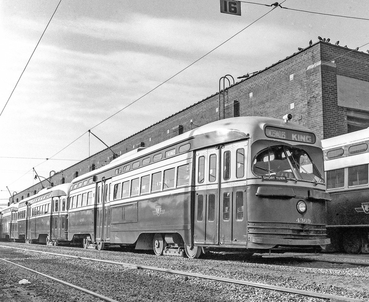 TTC 4369 is one of the PCC's sitting outside the Roncesvalles car house in Toronto sometime between 1969-1971.
