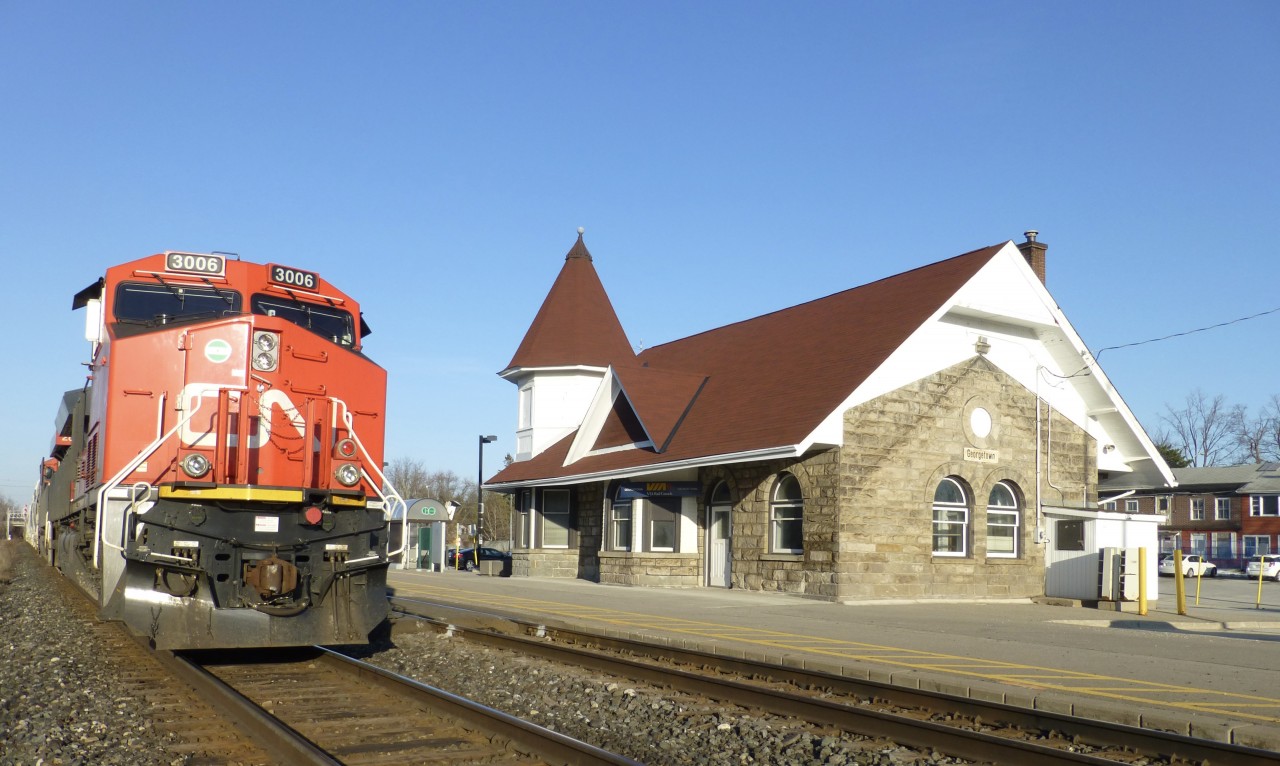 4/15/2016 my westbound  train led by ET44AC 3006 is stopped at the classic Georgetown station waiting for an eastbound to clear at Silver on CN'sHalton Sub.

The railway station was designed by Grand Trunk Railway and was built between 1855 and 1856.
In 1923, it became the Canadian National Railway and later became the VIA Railway. GO Transit service began in 1978.
The station once had a water tower for steam trains. Today it is a single-storey, stone, railroad station with a corner tower.
