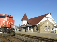 4/15/2016 my westbound  train led by ET44AC 3006 is stopped at the classic Georgetown station waiting for an eastbound to clear at Silver on CN'sHalton Sub.

The railway station was designed by Grand Trunk Railway and was built between 1855 and 1856.
In 1923, it became the Canadian National Railway and later became the VIA Railway. GO Transit service began in 1978.
The station once had a water tower for steam trains. Today it is a single-storey, stone, railroad station with a corner tower.