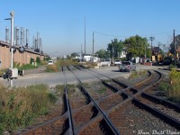 Another set of the diamonds, but not "the" diamonds: the rear truck of GO cab car 237 clatters over one of the diamonds for the <a href=https://www.railpictures.ca/?attachment_id=59294><b>CP connecting track</b></a> at West Toronto, that connected the MacTier Sub to the North Toronto Sub. Our train, GO #252, has just cleared Old Weston Road crossing on the double track CN Weston Sub and is still crossing over the <a href=http://www.railpictures.ca/?attachment_id=15154><b>actual diamonds</b></a> with the double track CP North Toronto Sub (out of view to the south). CP's <a href=http://www.railpictures.ca/?attachment_id=29758><b>MacTier Sub</b></a> mainline can be seen on the far right. In the distance, both CN tracks become one at <a href=https://www.railpictures.ca/?attachment_id=59199><b>CN Keele</b></a>.<br><br>Looking north, one can make out the old <a href=http://www.railpictures.ca/?attachment_id=41668><b>platforms </b></a>for the former <a href=http://www.railpictures.ca/?attachment_id=37086><b>CN West Toronto Station</b></a>, finally demolished only 8 years earlier. The fenced-in area where the station and express building once were was home to a compound lot used for storing snow removal equipment over the summer (the equipment was owned by Westridge Agriculture, which had one of the city snowplowing contracts, and they had rows and rows of old Champion and Wabco graders parked here). The building on the left was National Rubber Industries' Cawthra Ave plant. The <a href=http://www.railpictures.ca/?attachment_id=56951><b>Andrew Merrilees yard</b></a> was just out of view on the right. Judging by the machinery and pipes, there was some sewer or water main construction going on. Today, the old station grounds are gone, the connecting track is still there, but it now goes over both CN mainlines that have been grade separated into a giant trench below.