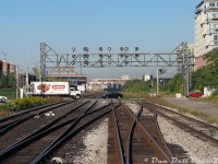 No, the cars aren't blowing the crossing: we're riding in the cab of GO cab car 237, trailing southbound on Bramalea-Toronto train #252 on the Georgetown line. The cab car is bucking over the crossovers at Strachan Avenue, just after clearing the grade crossing as traffic going through Liberty Village resumes and our train enters the Union Station Rail Corridor.<br><br>All that remained of this area around Strachan Avenue, railway-wise, in the mid-late 2000's was a busy grade crossing and a massive signal bridge. The old <a href=http://www.railpictures.ca/?attachment_id=35550><b>CP Parkdale Yard</b></a> (once on the left) had long been removed and replaced with housing, ditto for the old Massey Harris/Ferguson manufacturing facilities on the north side (to the right). Two old CP yard spotlight towers remained (one here at Strachan out of view to the left, the other visible in the distance near King St. underpass). Most of the manufacturing buildings here had been either torn down and redeveloped, or repurposed into lofts and condos (I recall that black building in the background was another M-F factory along King St. that was later demolished). The double-track mainlines for the CP Galt Sub (left) and <a href=http://www.railpictures.ca/?attachment_id=15195><b>CN Weston Sub</b></a> (right) remain. All of this was replaced with a <a href=https://www.railpictures.ca/?attachment_id=45668><b>large trench</b></a> a number of years later.