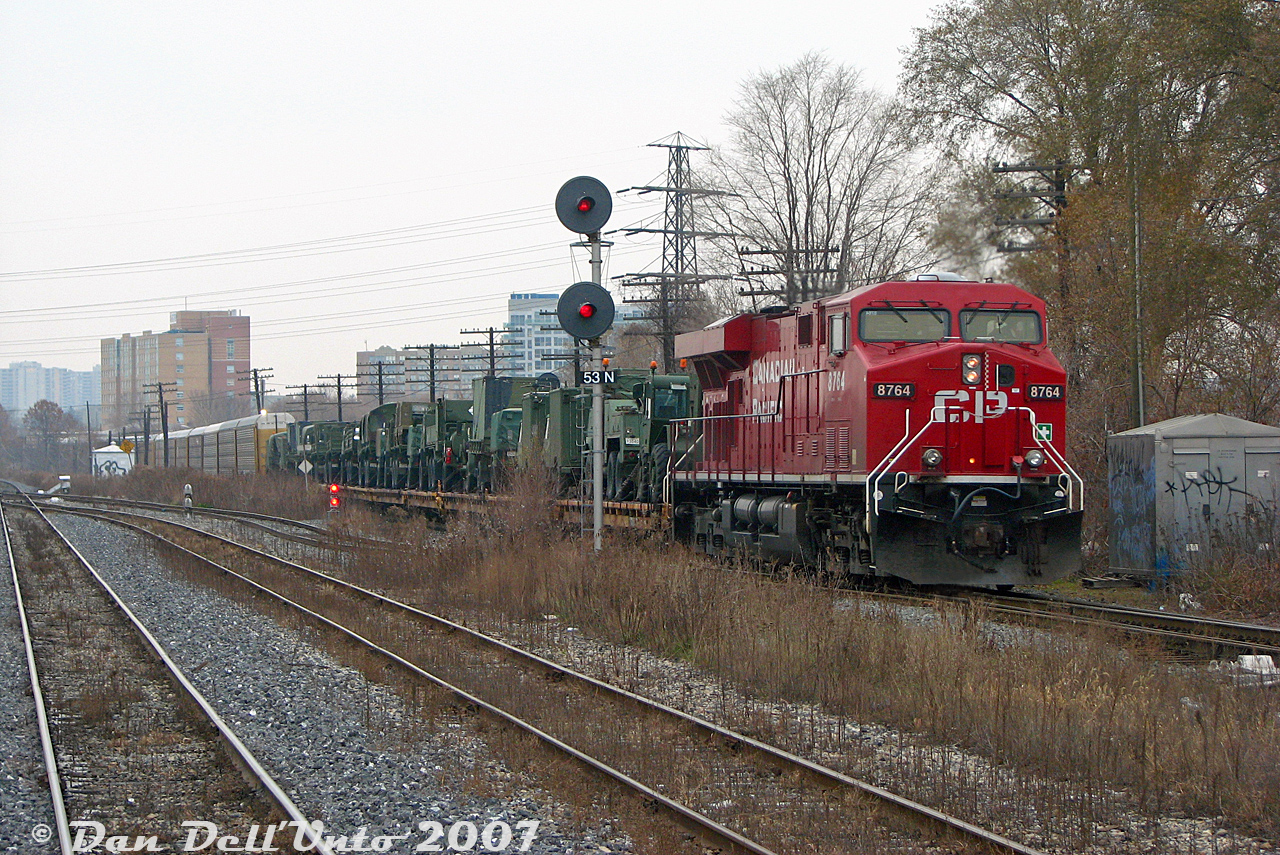 Right place, right time: during our GO train's wait at CN Keele (St. Clair Ave. W underpass) for the light at West Toronto to proceed south, CP train #116 shows up heading down the MacTier Sub with ES44AC 8764 in the lead, and a nice cut of green Canadian Armed Forces military vehicles on the head end (possibly bound for CFB Petawawa). The train is just passing the switch for the connecting track between the CN Weston Sub and CP MacTier Sub (allowing CN trains to enter CP's West Toronto/Lambton Yards to interchange traffic). In the foreground, the double-track CN Weston Sub turns into single track.

A few minutes later, GO #251 put in an appearance, snaking around our train on its trip north to Bramalea: https://www.railpictures.ca/?attachment_id=59199