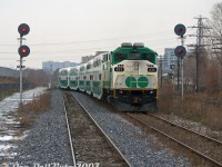 GO meet at CN Keele: GO Transit F59PH 532 splits the signals as it pushes on the rear of westbound Georgetown line train #251 (with cab car 231 leading the L8 consist), snaking off the double track section of the CN Weston Sub at Keele interlocking, and onto the single track gauntlet between Keele and Etobicoke North station (Rexdale). We're again riding in the cab of trailing cab car 201, on train #252 (with F59PH <a href=http://www.railpictures.ca/?attachment_id=11255><b>564</b></a> in the lead), stopped at the diamond enroute to Union Station downtown.<br><br>Whenever we took morning train #252 (the 9:05am from Bramalea to Union, a bit of a sleeper compared to the four hotshots from Georgetown) we had to meet train #251 (the 9:30am from Union to Bramalea). The uneventful passing usually occurred somewhere along this <a href=https://www.railpictures.ca/?attachment_id=59032><b>double-track section</b></a> from CN Keele to Bathurst Street/the USRC to minimize delays, typically somewhere around Parkdale. Today we had to wait for the light at West Toronto due to CN track work goings-on at the diamond, allowing #251 to sneak up and pass by us here onto the single track section at Keele. #251 would be the consist that went on to run service all afternoon on the <a href=http://www.railpictures.ca/?attachment_id=32906><b>"Bramalea Flip"</b></a>, while #252 would do a single southbound run, go out of service at Union and deadhead back to Willowbrook Yard.<br><br>CN Keele was located at Mile 5.3 of the CN Weston Sub, north of the West Toronto diamonds, just to the north of the St. Clair Avenue West underpass. The old CN West Toronto yards were once to the left (redeveloped into townhouses) and CN's own <a href=http://www.railpictures.ca/?attachment_id=14213><b>West Toronto Station</b></a> was just to the south. This spot was a bit out of the way and not often photographed, but it also hosted the connecting track to CP's MacTier Sub (pictured on the right amid the brush), allowing <a href=http://www.railpictures.ca/?attachment_id=34973><b>CN local freights like #577</b></a> access to CP's West Toronto/Lambton yards via the MacTier Sub and connecting track to interchange traffic with CP. CN Keele was eliminated when Metrolinx triple-tracked the line here, and extended the connecting track all the way to Black Creek Dr. underpass.