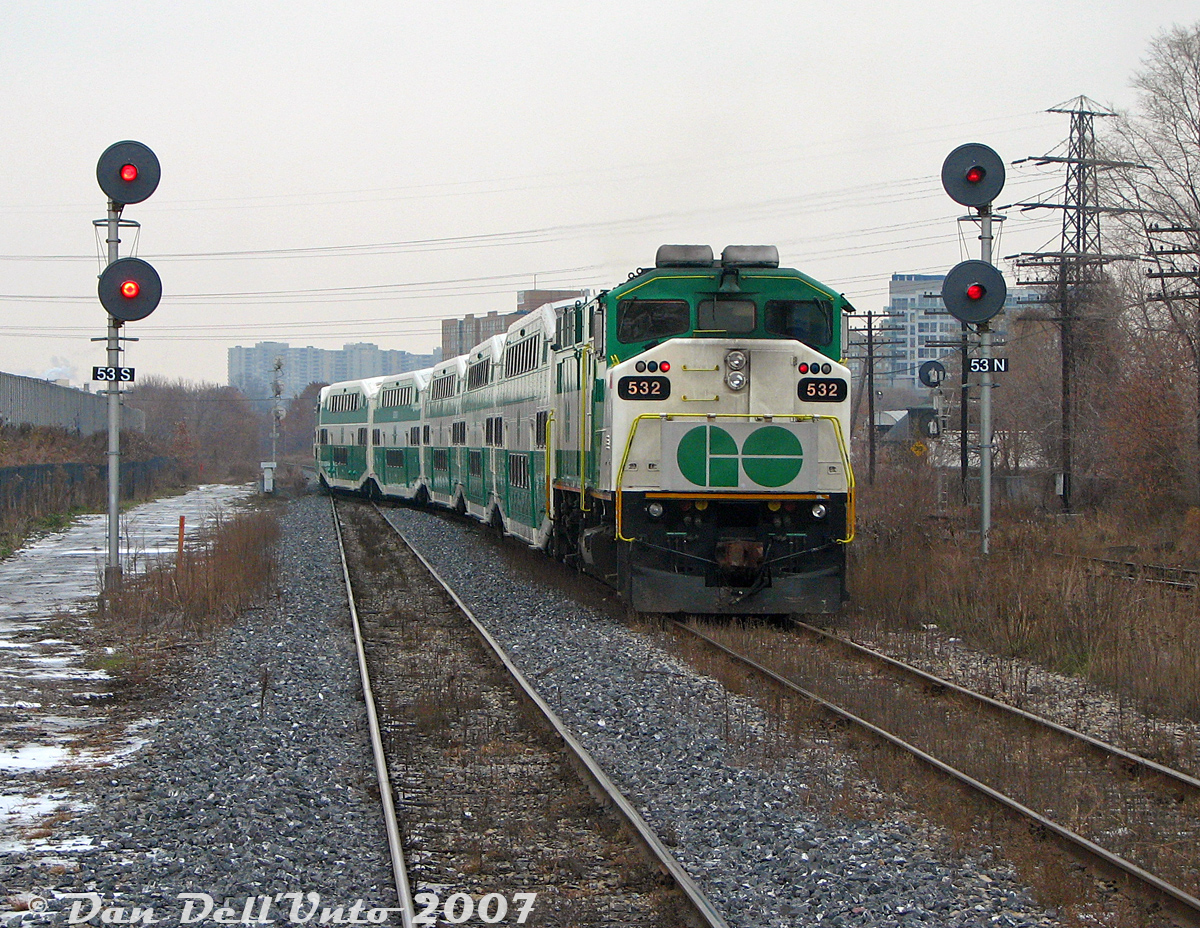 GO meet at CN Keele: GO Transit F59PH 532 splits the signals at Mile 5.3 as it pushes on the rear of westbound Georgetown line train #251 (with cab car 231 leading the L8 consist), snaking off the double track section of the CN Weston Sub at Keele interlocking, and onto the single track gauntlet between Keele and Etobicoke North station (Rexdale). We're again riding in the cab of trailing cab car 201 on train #252 (with F59PH 564 in the lead), stopped at the diamond enroute downtown to Union Station Toronto.

Whenever we took morning train #252 (the 9:05am from Bramalea to Union) we had to meet train #251 (the 9:30am from Union to Bramalea). It usually occurred somewhere along this double-track section from CN Keele to Bathurst Street/the USRC to minimize delays, typically somewhere around Parkdale. Today we had to wait for the light at the West Toronto diamond due to CN track work goings-on, allowing #251 to sneak up and pass by us onto the single track section at Keele. #251 would be the consist that went on to run service all afternoon on the "Bramalea Flip", while #252 would do a single southbound run, go out of service at Union and deadhead back to Willowbrook Yard.

CN Keele was located at Mile 5.3 CN Weston Sub, north of the West Toronto diamonds, just to the north of the St. Clair Avenue West underpass. The old CN West Toronto yards were once to the left (redeveloped into townhouses) and CN's own West Toronto Station was just to the south. This spot was a bit out of the way and not often photographed, but it also hosted the connecting track to CP's MacTier Sub (pictured on the right amid the brush), allowing CN local freights like #577 access to CP's West Toronto/Lambton yards via the MacTier Sub and connecting track to interchange traffic with CP. CN Keele was eliminated when Metrolinx triple-tracked the line here, and extended the connecting track all the way to Black Creek Dr. underpass.