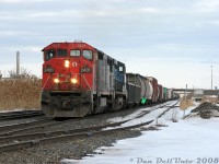 A double-dose of GE Dash-8's greets us on a somewhat overcast winter's day in downtown Brampton: CN train #393 lead by CN C40-8M 2431 and IC "Blue Devil" C40-8W 2455 approach the interlocking at Peel, on the climb up from Bramalea/Halwest to the now-short single track section in downtown Brampton (double-tracking still not completely finished).<br><br>This exact spot was the "old Peel" location behind The Brick near Kennedy Road and Clarence, as CN had recently moved the interlocking plant a few blocks to the west at Centre Street underpass during the Halton Sub double- and triple-tracking project (but everything still fed through a tiny single track section over the underpass, as the new #1 track to the east was not yet complete). The old yard on the right was once full of autoracks and boxcars for the old AMC Brampton Assembly plant at the south end of the <a href=https://www.railpictures.ca/?attachment_id=15922><b>Peel Village Industrial Lead</b></a>, once located at Steeles and Kennedy (built early 1960's, closed 1992). The busy Highway 410 overpass is visible in the distance.