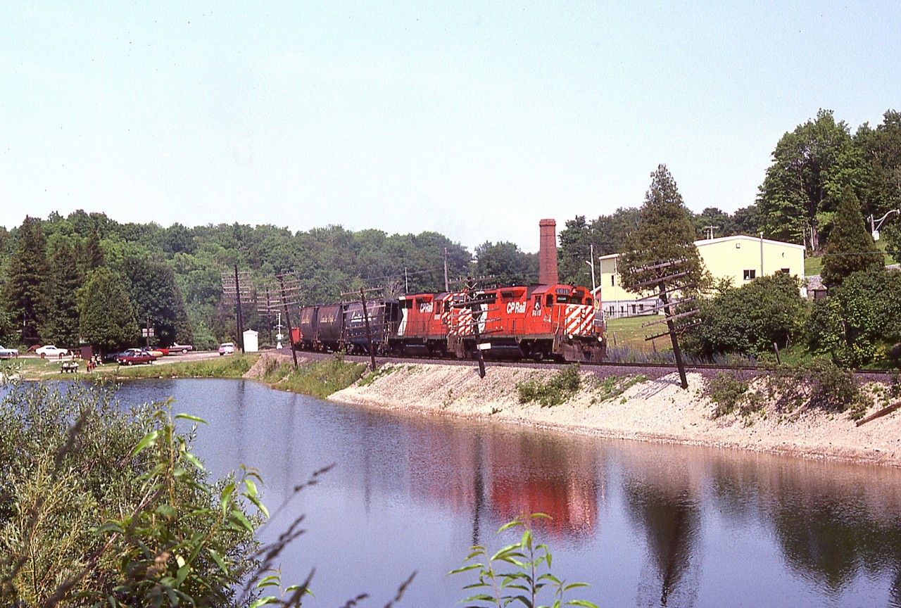 A perfect summer's afternoon in Campbellville down by the pond. Probably those at the picnic benches have little interest in what goes by. Heading west over the Guelph Line are a pair of GP35s, 5015 and 5007; a model that is now but a memory on the CP. These two, as well as numerous others, were sold to Helm Financial in 1998/99.