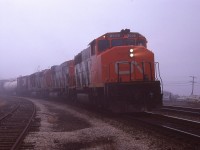 For whatever reason I did not get to recording the unit numbers behind this westbound freight led by CN 9505. It looks to be one heck of a gloomy day. Maybe my pen would not write. I dunno.  But note even with weather conditions about as lousy as they could get, outside of pouring rain; the usual gang is showing up as seen by the cars visible on the right.  Somehow, we made it all fun.  Cheers!!!
