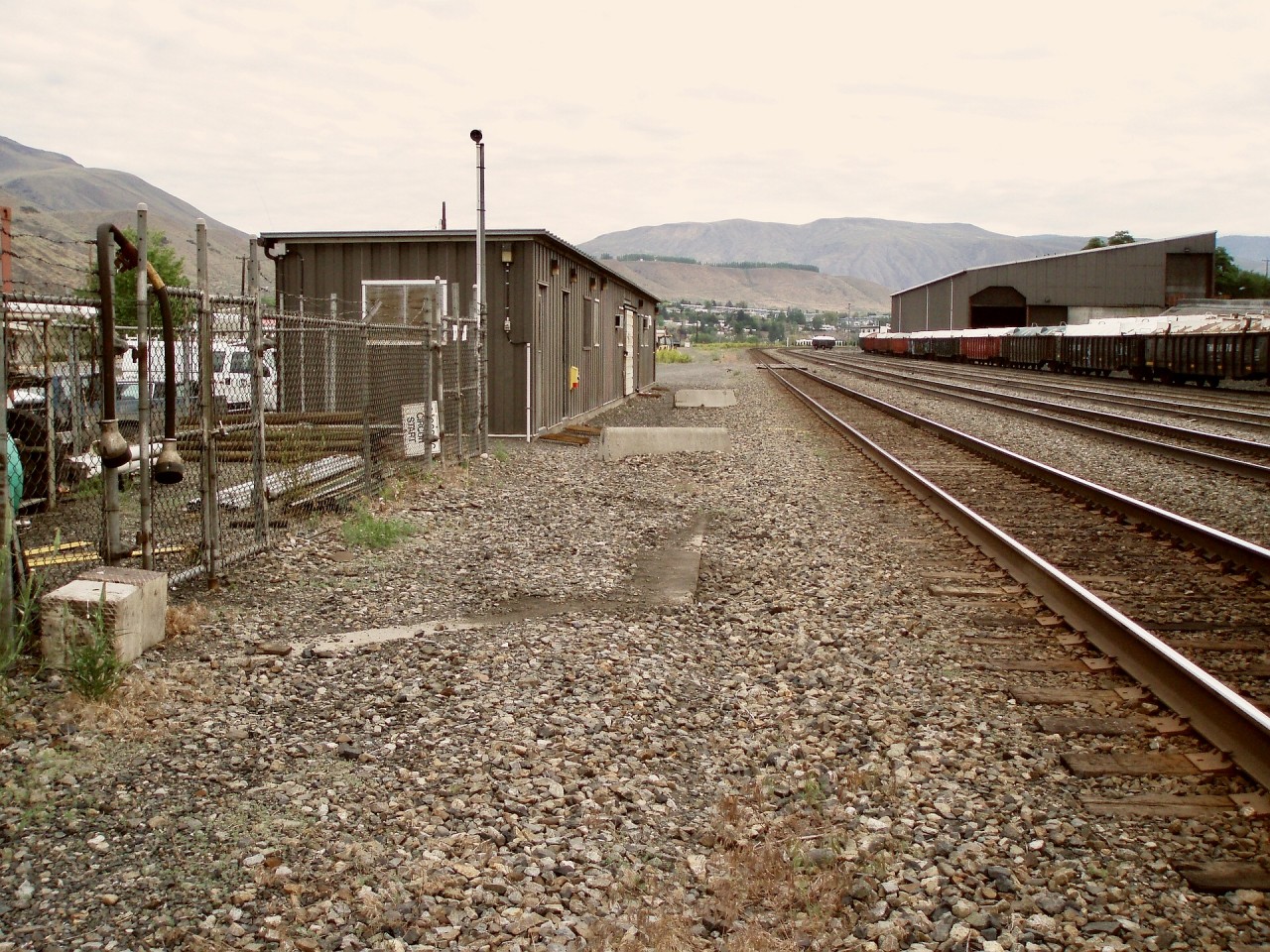 While working a temporary assignment based at Ashcroft, a wander around the maintenance-of-way office revealed the concrete octagon base for the final water tower location there, seen here viewed compass northward (timetable east) on Tuesday 2007-06-05, slightly cleared of loose ballast.