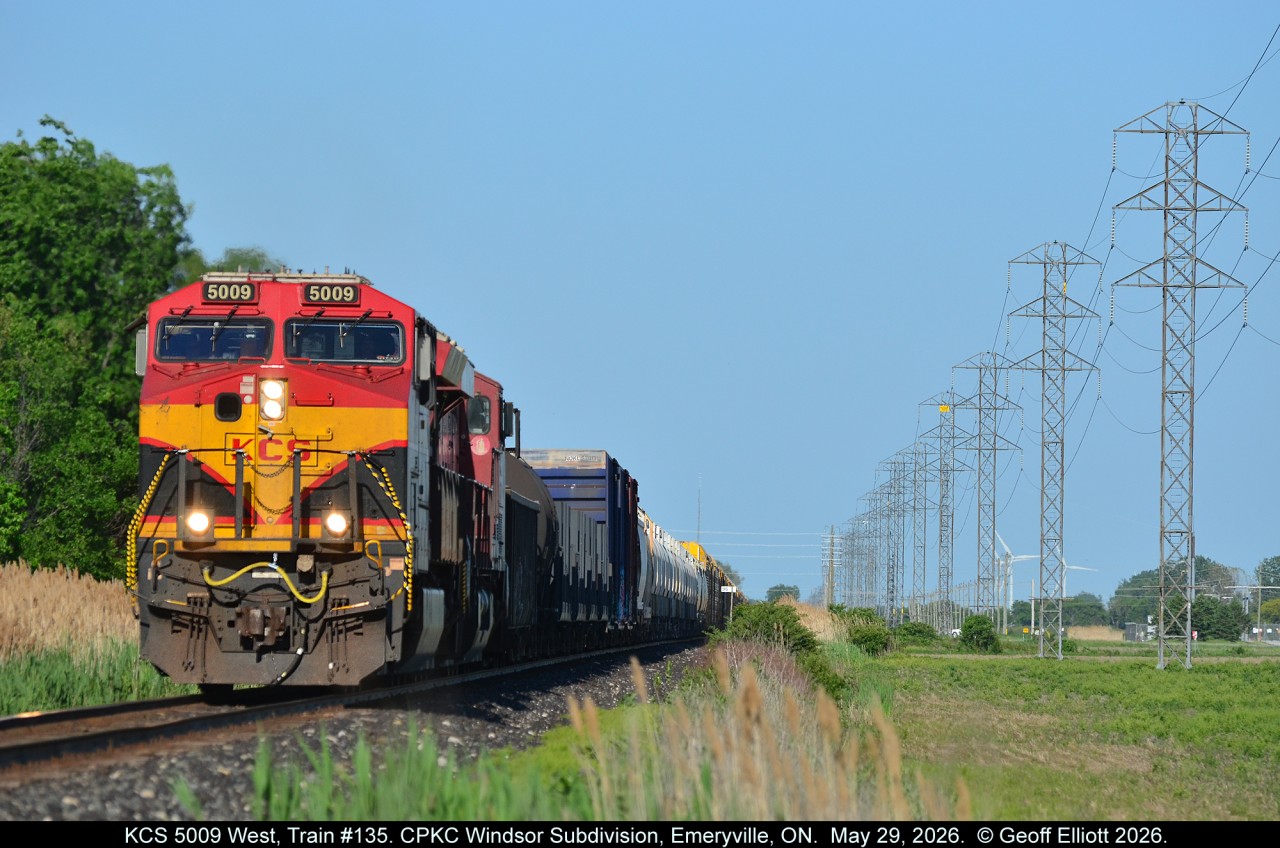 CPKC Train #135 hurries across Essex County, bound for Windsor, in the late afternoon sun with KCS ET44AC #5009 on point as it approaches Renault Line in Emeryville, Ontario on May 29, 2026.
