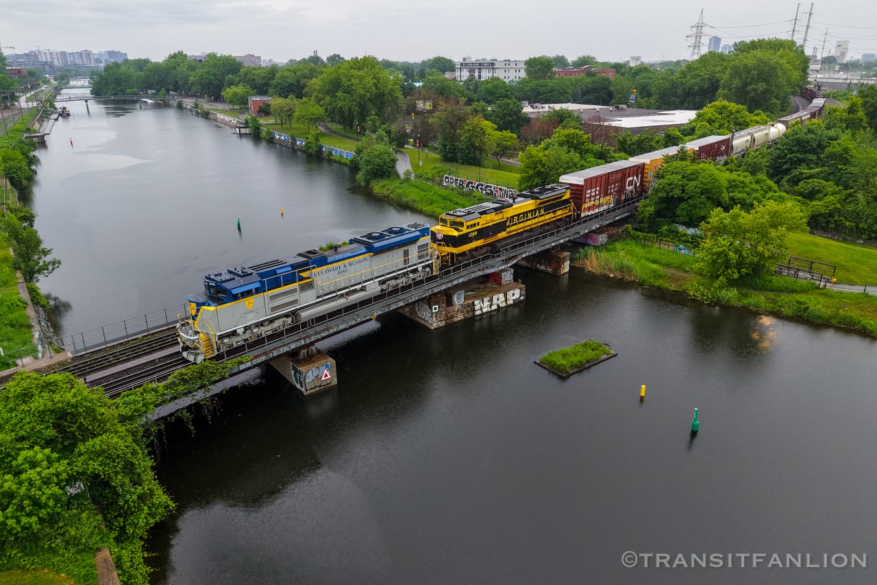 Tri-weekly Taschereau yard to Rouses Point turn CN L52921 18 returning with Delaware & Hudson heritage unit NS 1080 and Virginian heritage unit NS 1069 for power, crossing over Canal Lachine prepare to stop at St-Henri for VIA 31.