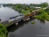 Tri-weekly Taschereau yard to Rouses Point turn CN L52921 18 returning with Delaware & Hudson heritage unit NS 1080 and Virginian heritage unit NS 1069 for power, crossing over Canal Lachine prepare to stop at St-Henri for VIA 31.