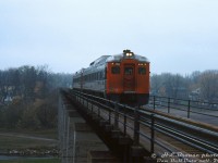 CN RDC-1's 6120 and 6119 cross the bridge over <a href=http://www.railpictures.ca/?attachment_id=21024><b>Trout Creek</b></a> in St. Mary's on a gloomy rainy day, operating on a fantrip around Southern Ontario. Some attendees are visible aboard during this photo stop/run-by, including one bearing a camera. Photo stops included Lucan Crossing, Forest, St. Mary's Junction, St. Thomas, and a visit to Port Stanley.
<br><br>
<i>Harold E. Brouse photo, Dan Dell'Unto collection slide.</i>