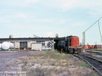 CN S3 8473 spots some cars behind CN's Belleville Roundhouse. Since they're both tank cars and the engine servicing facilities are alongside on the right, they might be spotted here for unloading diesel fuel into those large white tanks marked "FLAMMABLE, KEEP FLAMES AWAY, NO SMOKING" in big lettering (just a guess...). Some snowplows and boxcars can be seen near the turntable area in the distance. There looks to be a flanger or caboose visible inside the roundhouse (perhaps this was an indoor car repair track?).
<br><br>
<i>Keith Hansen photo, Dan Dell'Unto collection slide.</i>