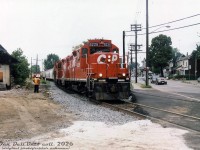 CP GP9u 8226, probably on one of the Emery Turns, heads south on the MacTier Sub connection track enroute the West Toronto/Lambton Yards, crossing Old Weston Road and passing railway employees and demolition crews with their Hitachi excavator in the process of tearing down the old CN West Toronto Station.<br><br>The demolition of <a href=http://www.railpictures.ca/?attachment_id=14408><b>CP's West Toronto station</b></a> has been well-covered in the past, but demolition of <a href=http://www.railpictures.ca/?attachment_id=14213><b>CN's West Toronto Station</b></a> to the north has received little attention. It continued to see passenger use into the 1980's under VIA Rail, but by 1990 any passenger stops were gone (possibly a victim of the 1990 VIA cuts). Its importance also likely diminished when GO Transit started Georgetown line operations in 1974 and opted for their own new GO station at Bloor Street, closer to the TTC's Bloor-Danforth subway, rather than using CN's existing station here. According to notes by the late Toronto railway historian Derek Boles, both the CN station and express shed were severely damaged by a three-alarm fire on October 21st 1993, after being vacant/out of use for a number of years prior. <a href=https://flickr.com/photos/collations/4275529230/><b>Photos after</b></a> show it boarded up in a state of decay (the roof on the north end was much more damaged, and falling in). A bit more digging shows the station was eventually demolished years later around August 1999, after suffering from the aforementioned fire and years of vandalism. The vacant CN property in the middle of both CN and CP rail lines then became a compound yard for storing City of Toronto contractor snow removal equipment (with parts of the old station platform still visible), but was eventually all obliterated for the Metrolinx/GO West Toronto grade separation trench.<br><br><i>Original photographer unknown, Dan Dell'Unto collection print.</i><br><br>Note: this photo was a scan of an old print purchased from a train show back in the early 2000's, probably at one of the large annual CARM ones held at the Toronto Congress Centre every year. Unfortunately, no photographer or description was noted on the print, but from research I was able to narrow the demolition down to 1999.