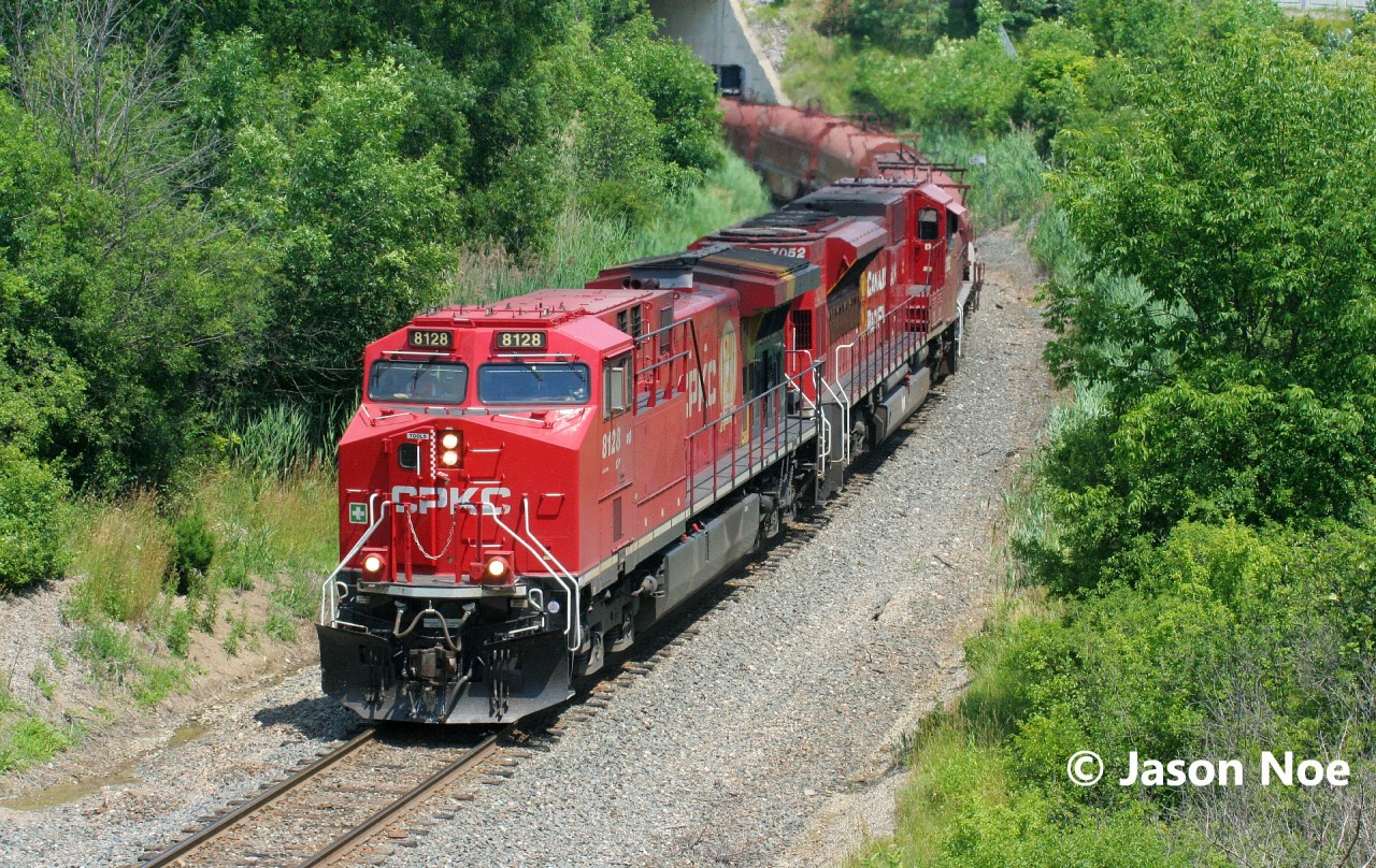 CPKC train 236 is seen entering Hamilton, Ontario as it drops down the grade approaching Newman Road on the Hamilton Subdivision. Powering the southbound are CPKC AC4400CWM 8128 and CP SD70ACu 7052.