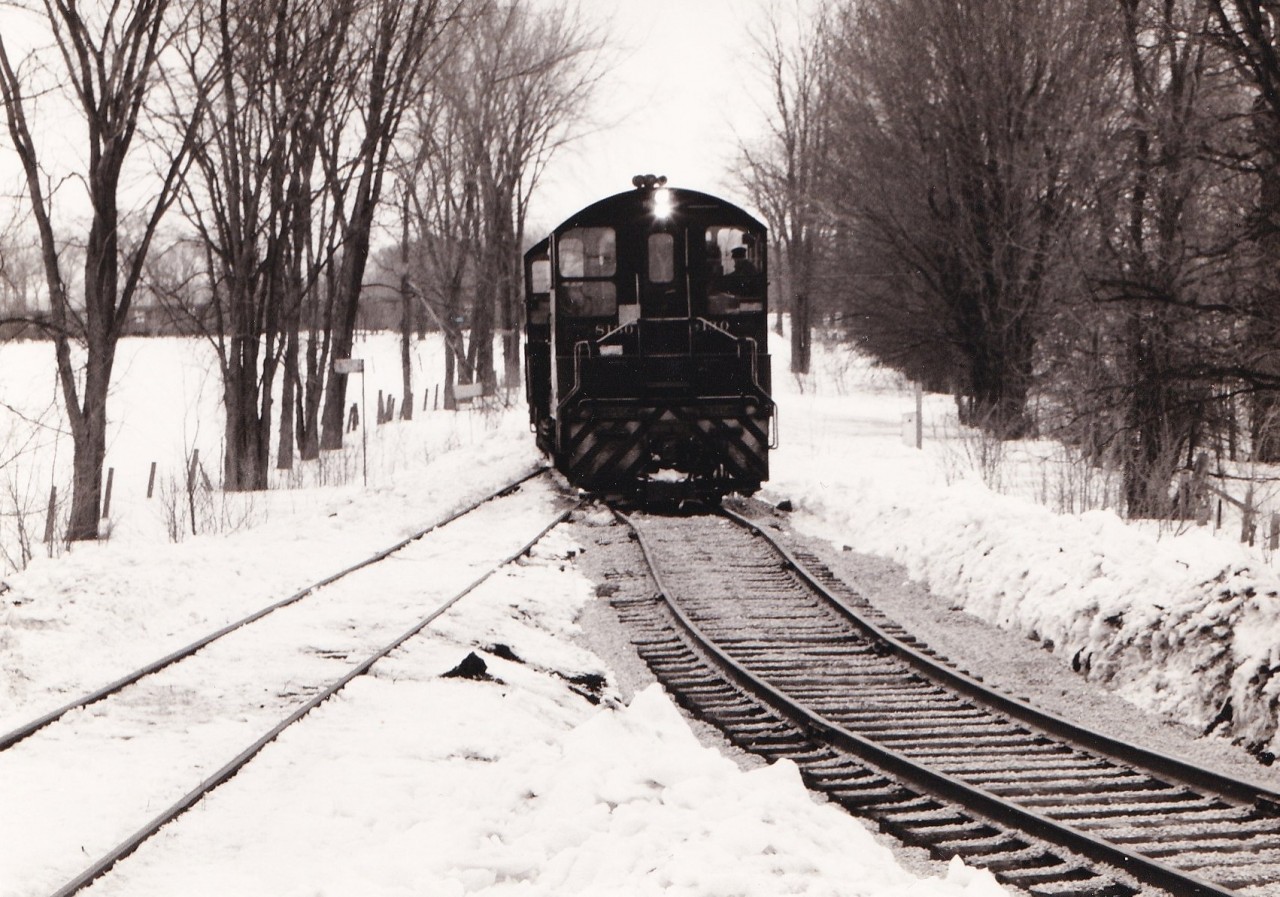 A pair of SW1200RS units enter the newly completed diversion track between the CNR Coldwater spur and the remnant of the CPR Port McNicoll subdivision.

This connecting track permitted CP to reach the CNR Midland sub at Coldwater when the large Hoggs Bay trestle was abandoned in 1971. A similar connecting track was built between McMillan on the Midland sub and the yard at Port. Prior to this CP had an interlocked  diamond crossing of the CN spur. CP used trackage rights on CN to reach McMillan until 1991 when the Port McNicol sub was abandoned. The diamond remained in place for several years until the unused rails were lifted between this point and the trestle.

The connecting track originally dipped south of the existing track before connecting to the existing track near the bridge over the Coldwater river. The connecting track was later reconfigured to a more conventional turn in the 1980's due to difficulties with long trains. Six axle units were prohibited on this later track arrangement. Our family rode a UCRS excursion to Midland that went through this trackage in 1975. It was an interesting sight watching the 80 foot long coaches negotiate the shoofly.

The County of Simcoe mapping website (https://opengis.simcoe.ca/public/) has aerial views of this area. The 1978 and 1983 views show the two different layouts.

Unknown photographer from my collection.