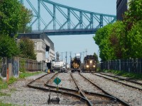 IC 9628 leads CN 500 as it passes MOW vehicles at the western end of Port of Montreal trackage.