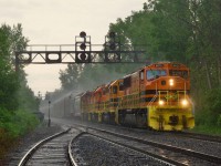 QG 502 is northbound on CPKC's Adirondack Sub in Montreal under a wall of rain with  QGRY 4015, QGRY 3102, QGRY 3539 & QGRY 3538 for power. Even with a raincoat and an umbrella, I still got soaked (in fact I was already calling it a day and walking off when I saw the train come around a corner).