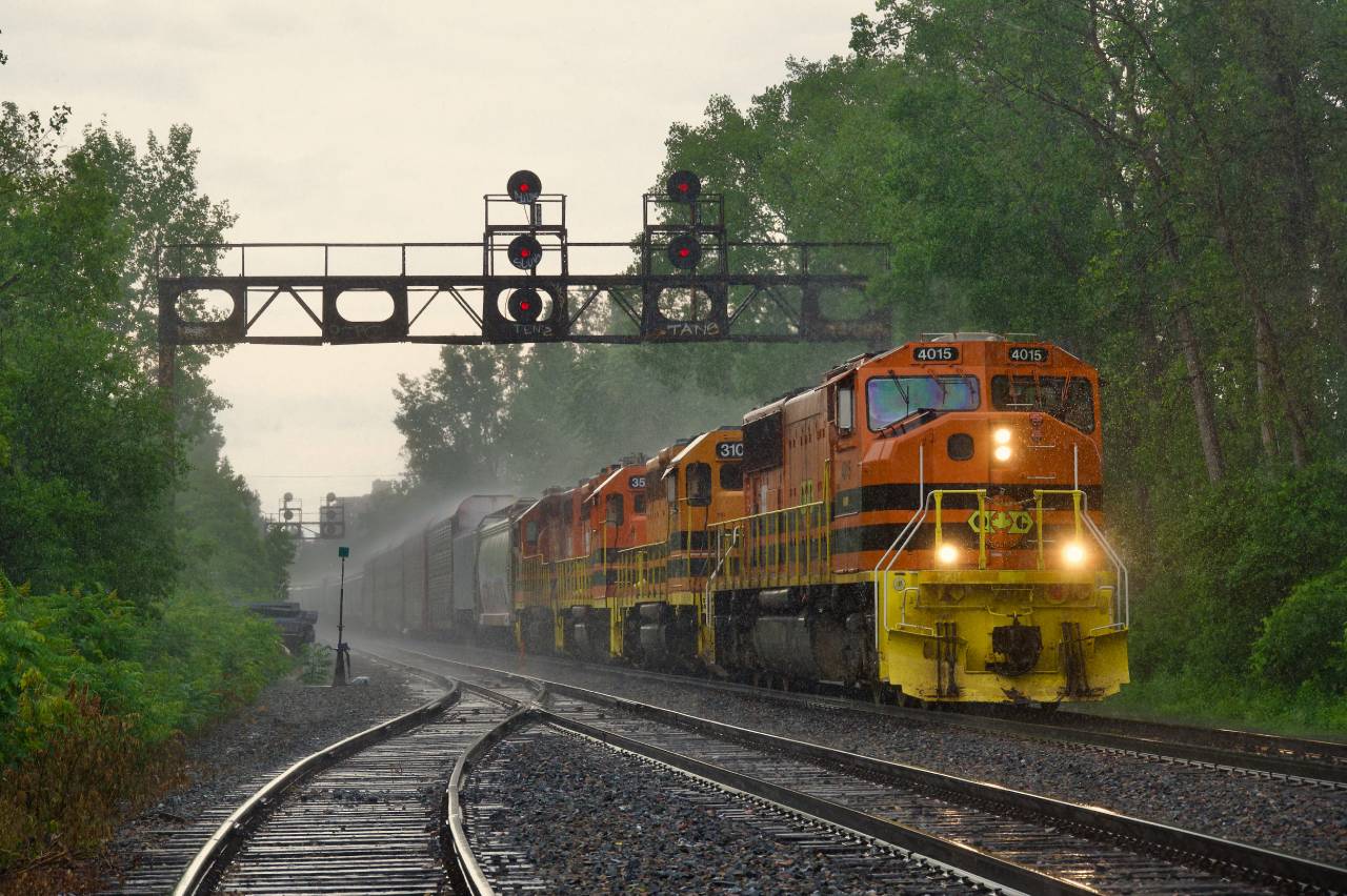 QG 502 is northbound on CPKC's Adirondack Sub in Montreal under a wall of rain with  QGRY 4015, QGRY 3102, QGRY 3539 & QGRY 3538 for power. Even with a raincoat and an umbrella, I still got soaked (in fact I was already calling it a day and walking off when I saw the train come around a corner).