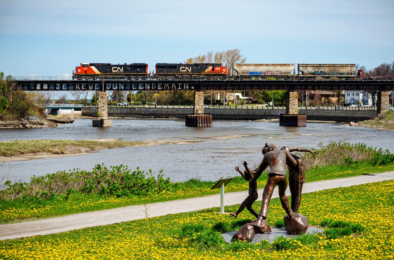 AC Traction power, a not too common sight on the Mont-Joli subdivision, pulls train 403 over the Rimouski river. In the foreground, we can see one of Roger Langevin's sculptures.