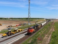 Eastbound (M392) operating DP 2-1-0 makes it way through Ash passing on going construction works for the future Milton Logistics Hub. The recently completed overpass supports the access road off Britannia Road. In the distance grading continues for the yard tracks. A ballast regulator and production/switch tamper are at the ready to lift and surface the freshly ballasted future north and south tracks toward Derry. 


