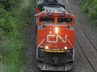 CN 8918 is in charge of a long manifest as it rounds the bend at Denfield Bridge this afternoon.