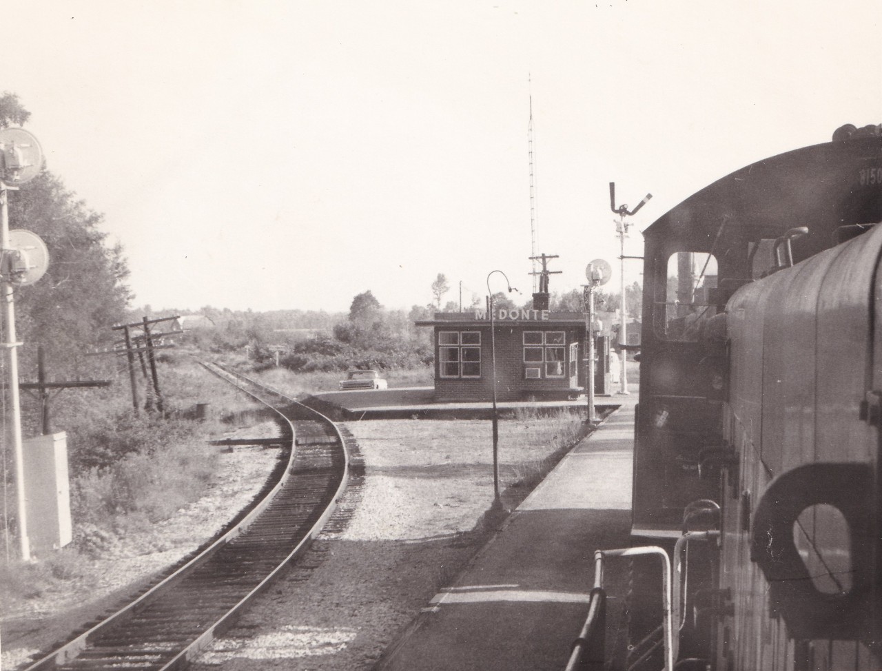 A view of the Medonte station taken from the lead unit of the Port McNicoll roadswitcher. The track on the left is the connection to the Port McNicoll subdivision with the mileboard for Coldwater seen on the right. It must be summer as the air conditioner has been installed in the waiting area window. The date is approximate. Unknown  photographer from my collection.