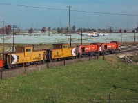 Looking north east from Finch Avenue, a pair of MLW S4 switchers work a cut of cars around the yard.  Both legs of the wye to a customer out of frame at left alongside the large parking lot are visible, and can be seen <a href=https://www.toronto.ca/ext/archives/s0012/fl1975/s0012_fl1975_it0235.jpg>in this 1975 aerial view.</a>  Today, the west leg has been removed, but other costumers remain on the short spur branching off here, including Agincourt's automotive facility.

<br><br><i>John Freyseng Photo, Jacob Patterson Collection Slide.</i>