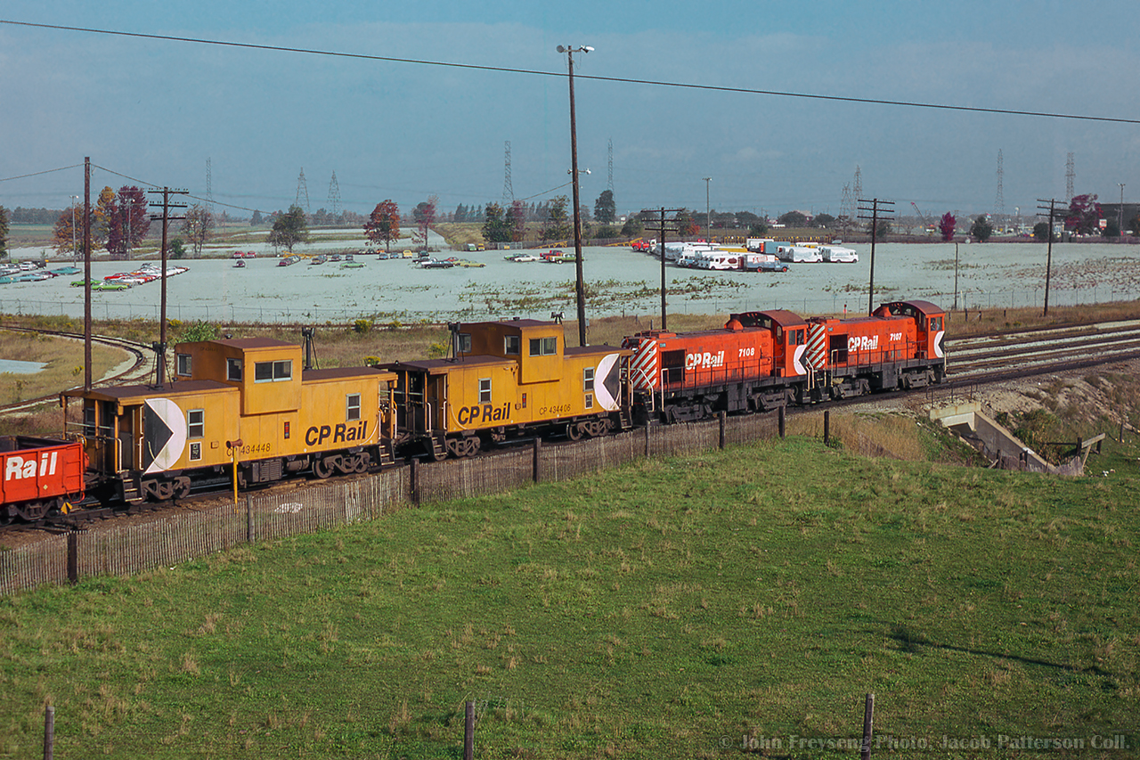 Looking north east from Finch Avenue, a pair of MLW S4 switchers work a cut of cars around the yard.  Both legs of the wye to a customer out of frame at left alongside the large parking lot are visible, and can be seen in this 1975 aerial view.  Today, the west leg has been removed, but other costumers remain on the short spur branching off here, including Agincourt's automotive facility.

John Freyseng Photo, Jacob Patterson Collection Slide.