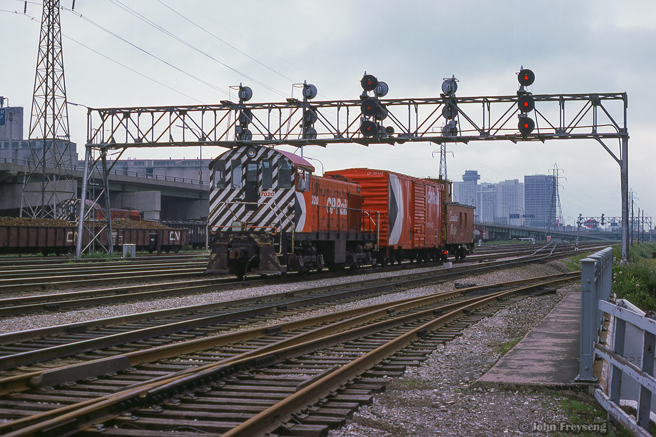 CP 7020 makes its way through Toronto Terminals Railway trackage at Cherry Street with a single box car and van, while another small ALCO/MLW switcher can be seen to the south of the main near Don yard.  Built in 1944, CP 7020 remains on display at the former John Street roundhouse.

Scan and editing by Jacob Patterson.