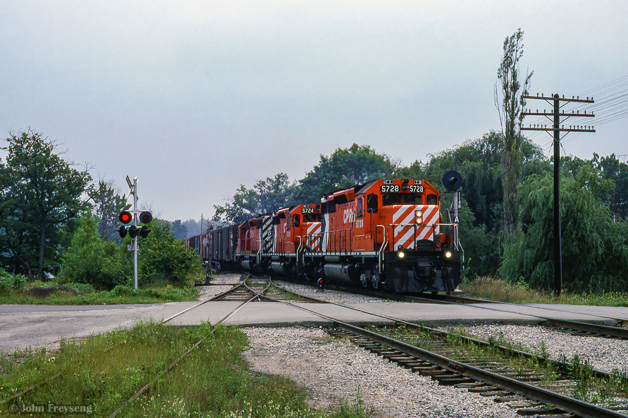 Three SD40-2s rumble through Bala with a northbound freight, passing over the south siding switch and the Gordon Street crossing.

Scan and editing by Jacob Patterson.