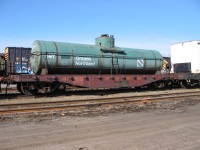 <b> Kit bashed </b> <br>
Here's one for the modelers. <br>
ONT 1699 (ex-ONT 100201-100299 series flat car, NSC built June 1940) has ex-ONT 1595 'water storage only' tank strapped to its deck as they sit on a deadline in ONR's North Bay, ON yard May 4, 2004. <br>
Although it is now 24 years ago, I remember that day quite well as there was so much to view and shoot as I walked around the shops and yard for hours on that clear and sunny day. :-)