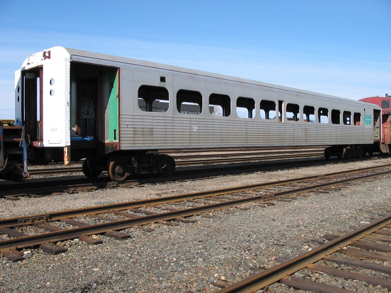 No GO  
Stenciled ONT 613 on the vestibule end, this ex-GO Transit commuter car sits on the well-stocked deadline in the ONR yard at North Bay, ON May 4, 2004. 
Hawker Siddeley built in 1967 and retired in 2001, it has found its way, with several other retired GO Transit cars to North Bay for rebuild, or as a parts doner. 
Also on this day, ONT 608 (ex-GOT 1030, exx-GOT 9930, nee GOT 4730) was in the lineup and looking pretty sad as well.