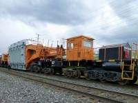 This is a very unusual piece of railway equipment with a specific purpose 
HEPX 2000 is stopped waiting for a train to clear. Because of the size 
of the transformer, we have multiple restrictions across the entire route.
Including not being allowed to have other trains beside our train. 
Makes for a very long day!
On 5/8/2016 we moved this transformer from Hamilton to
Ontario Hydro's Pickering Nuclear power plant.

Question time?
1 What is this car called?
2 What makes this car unique in more ways than one?
3 What are the 6 axle  trucks at the ends of the car known as?
