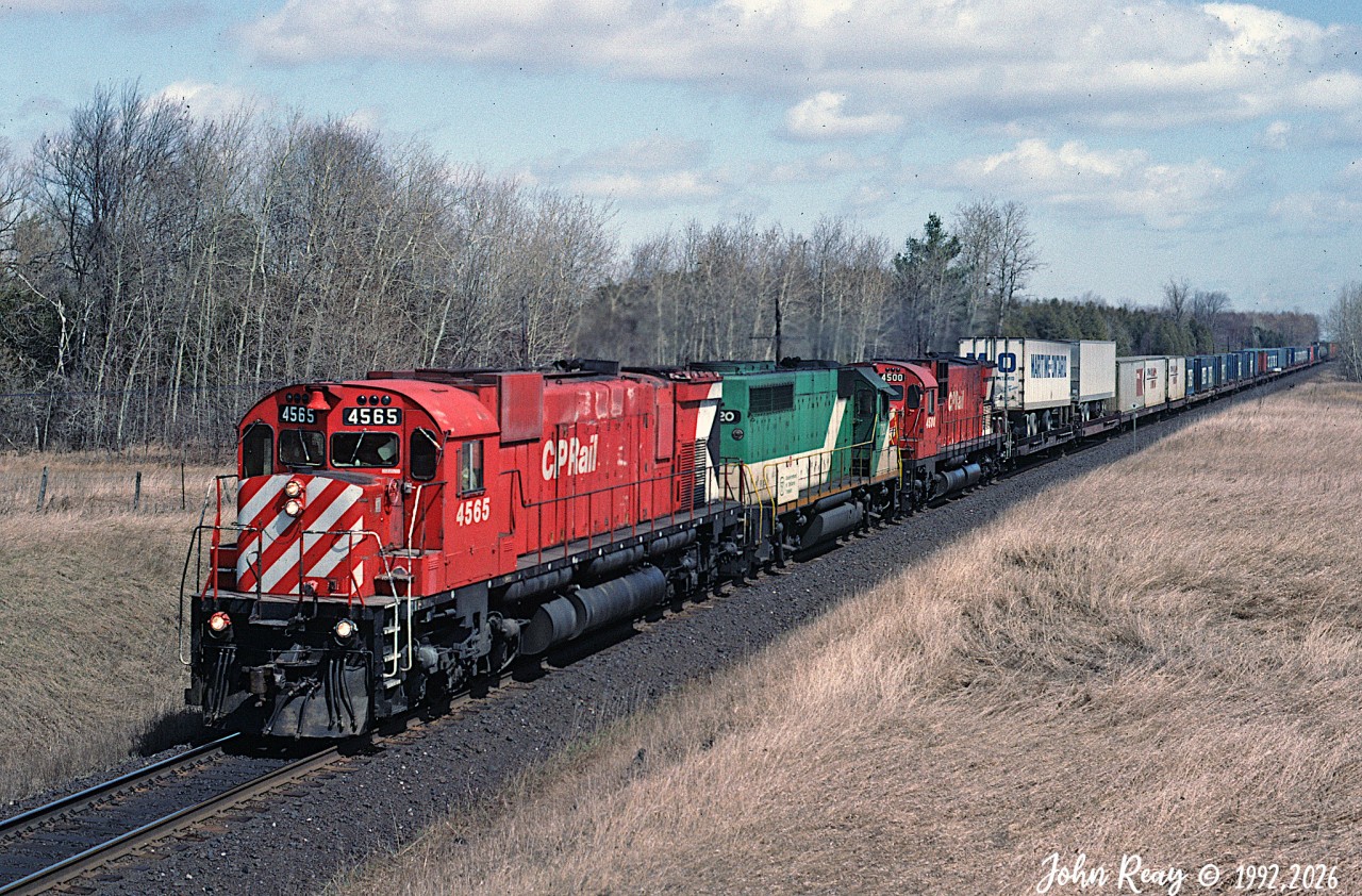 CP M-630 4565, GO Transit GP40-2 720, CP C-630M 4500 leading CP train 505 at milepost 150 Belleville sub in early May 1992. I used hang out here on Friday nights in the late eighties to late nineties to watch the action on CP and the parallel CN KIngston sub. Accessed from between the late lamented twin wooden bridges at Nichols Road, Newtonville.