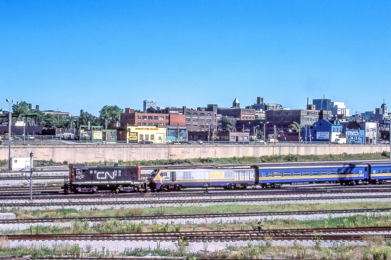 CN 8512 is moving VIA 6911 and what is possibly her train in Toronto on August 25, 1984.
